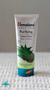 A white tube of Himalaya Purifying Neem Pack with Neem and Turmeric, standing vertically on a white textured surface with the Everything Enchanting logo displayed in the bottom-left corner.