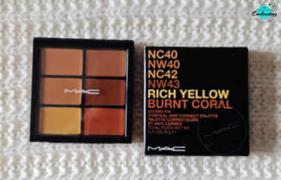An open MAC Studio Fix Conceal and Correct Palette featuring six cream pans in warm skin tones and color-correcting shades next to its black packaging box, resting on a white textured knitted background with the Everything Enchanting logo in the top-right corner.